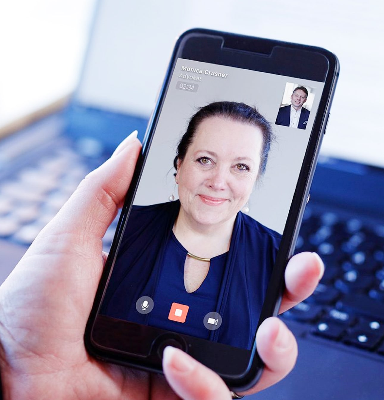 A client holds a smartphone with the Rätt app and having a video call with a lawyer